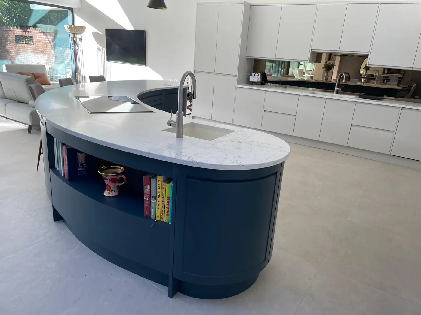 Open-plan kitchen with a curved island on large stone floor