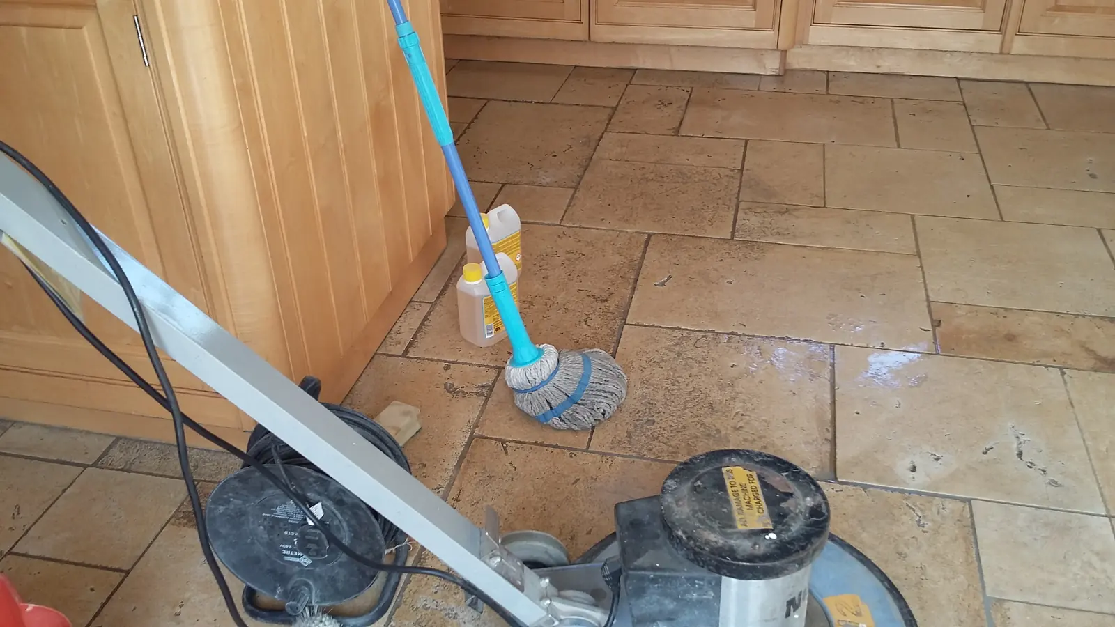 A stone floor part-way through a deep clean
